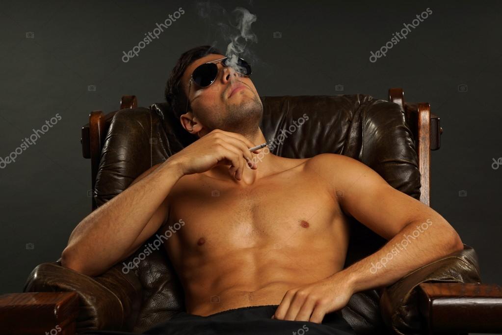 A Man in Black Shirt Wearing Sunglasses Smoking Cigarette · Free Stock Photo