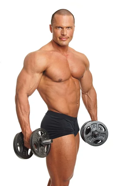 Muscular man exercises with dumbbell — Stock Photo, Image