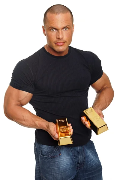 Homem muscular mostra-lhe tijolos de ouro — Fotografia de Stock