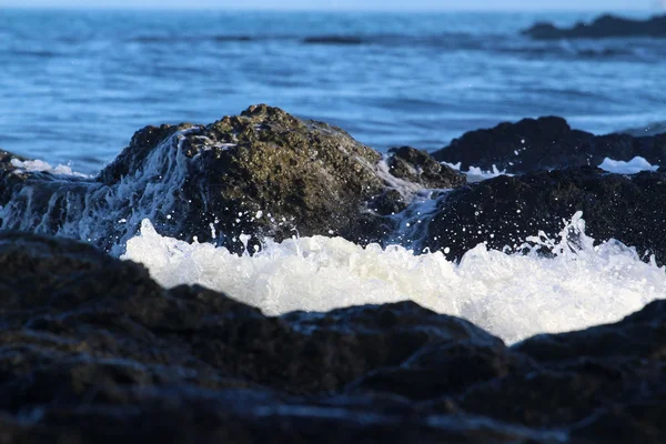 Yukarı kayalar arasında sıçramasına dalgalar