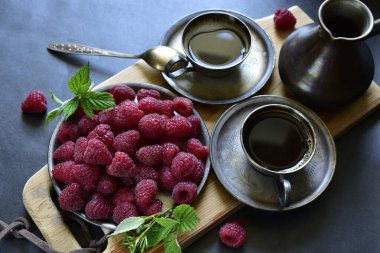 Kahveli fincanların en üst görüntüsü ve ahududu ahşap tahtada.