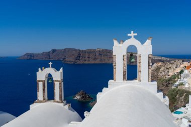 Oia kasabası ve ünlü beyaz kule çanları ve ortodoks kiliselerinin mavi kubbeleriyle Santorini Kalderası manzarası