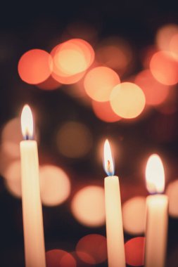 Güzel renkli bir çemberin önünde yanan üç mum. Parlak bir arka plan.