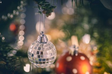 Noel ağacından sarkan gümüş ve kırmızı takılar. güzel yeşil ve beyaz bulanık arkaplan