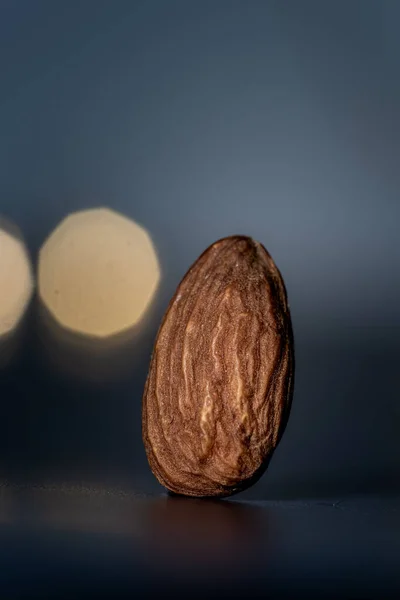 Close Isolated Almond Standing Dark Table Dark Background Lights Close — Stock Photo, Image