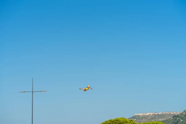 yellow fire-fighting plane is going to throwing water on fire at marseille airport.