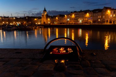 Gece La Rochelle 'in eski limanında aydınlatılmış bir demirlemenin ayrıntıları. Arka planda bulanık şehir ışıkları