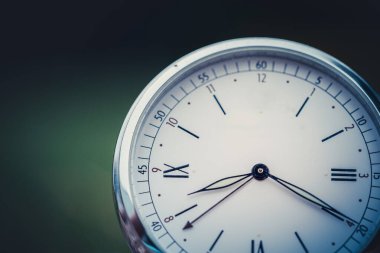 Ahşap arka planda klasik saat. Zaman geçirmenin sembolü olarak eski bir saat. Tarih teması, nostalji, yaşlılık kavramı. Retro biçimi.