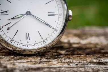 Ahşap arka planda klasik saat. Zaman geçirmenin sembolü olarak eski bir saat. Tarih teması, nostalji, yaşlılık kavramı. Retro biçimi.