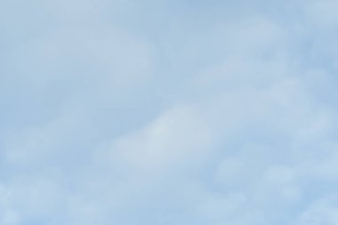 Mavi gökyüzünde hafif kabarık bulutlar beyaz yumuşak doku deseni gösteriyor