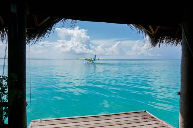Turkuaz maldivian lagününden bir deniz uçağının kalkışı. Lüks seyahat konsepti