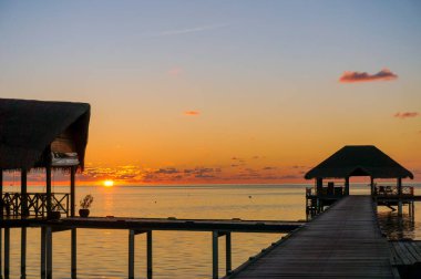 Gün batımında Maldivler 'deki Hint Okyanusu' nda ahşap bir kulübe. Güzel gökyüzü, bulutlar ve yaz tatili ve seyahat konsepti için plaj arka planı.