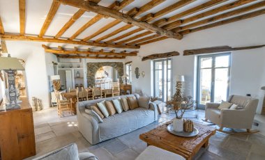 Güzel ve büyük oturma odasının içinde doğal taş döşemeler ve yeni lüks bir evde görünür kirişler var..