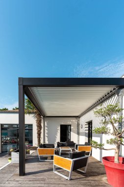 Açık hava pergola gölgelik yapısı, tente ve teras çatısı, bahçe salonu, sandalyeler, peyzaj ile çevrili metal ızgara.