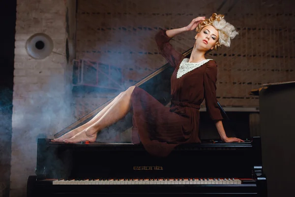 ピアノに横たわっている茶色のドレスのモデル — ストック写真