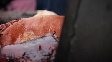 Prag 'ın Noel pazarında Prag jambonu pişiriliyor. Yaklaş. Düşük açı, hareket, yavaş çekim, HD.