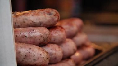 Prag 'ın sosisi Prag' ın Noel pazarında pişiriliyor. Kapat. Orta açı, seyahat hareketi, yavaş çekim, HD.