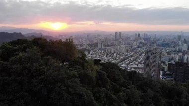 Fil dağı ve Taipei şehri üzerinde hava aracı gün batımı görüntüsü, Tayvan. Orta açı, parallax hareketi, HD.