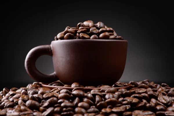 Cup with coffee beans on a black background — Stock Photo, Image
