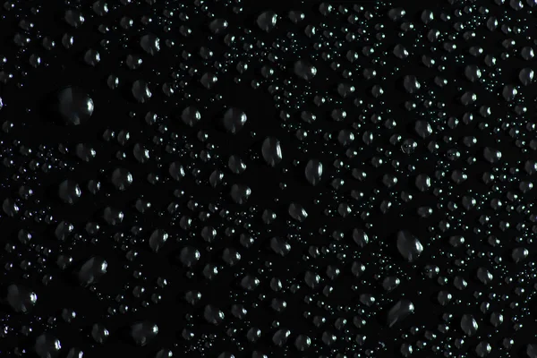 Gotas de água na superfície preta — Fotografia de Stock