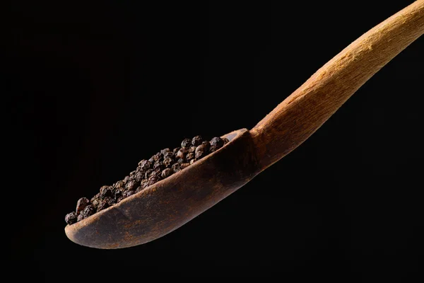 Poivre noir dans une cuillère en bois — Photo