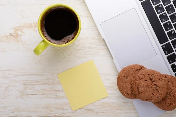 Laptop ile kahve fincanı ve aperatif masada