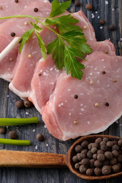 Bistecca di carne cruda su tavola di legno con spezie e sale — Foto Stock