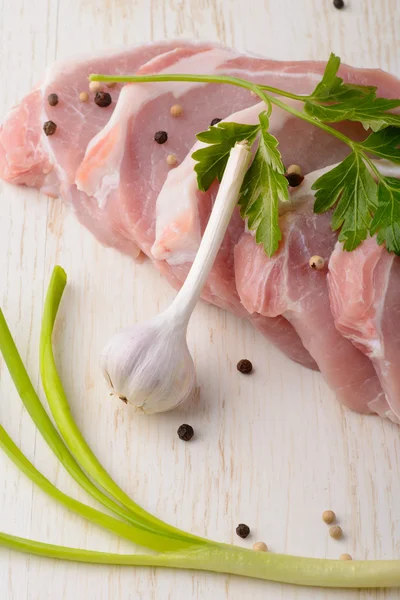 Bistecca di carne cruda su tavola di legno con spezie e aglio — Foto Stock