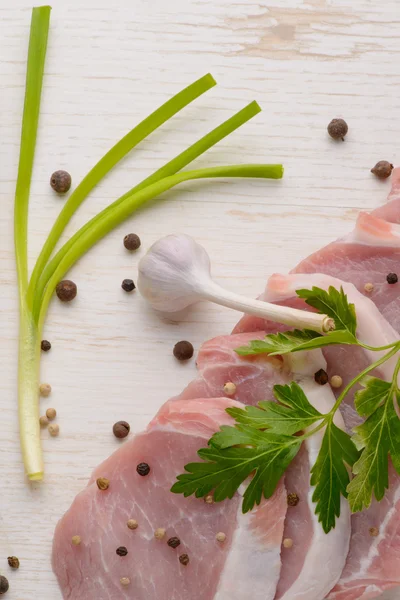 Steak de viande crue sur planche de bois avec épices et ail — Photo