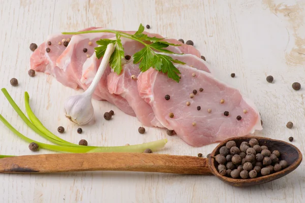 Raw meat steak on wooden board with spoon spices and garlic — Stock Photo, Image