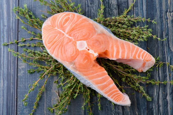 Salmão cru com tomilho em uma tábua de madeira. close-up — Fotografia de Stock