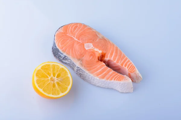 Roher Lachs mit Zitrone auf weißem Hintergrund — Stockfoto