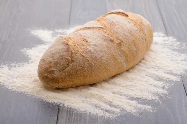 Bochník bílého chleba na dřevěný stůl — Stock fotografie