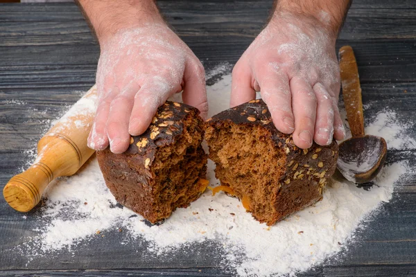 Svart bröd i händerna på männen — Stockfoto