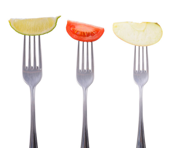 tomato, lime and apple on a fork