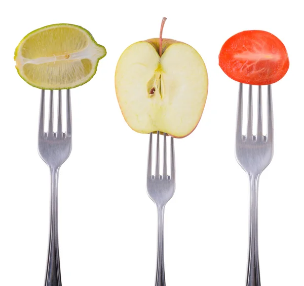 Lime, apple and tomato on a fork Stock Picture