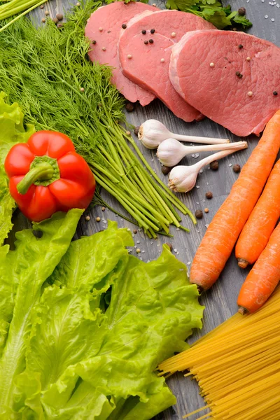 Raw meat with vegetables and uncooked spaghetti — Stock Photo, Image