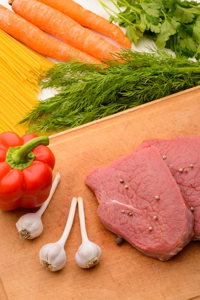 Rauw vlees op het bord met knoflook en peper — Stockfoto