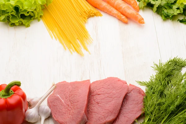 Viande crue, pâtes et légumes sur la table — Photo