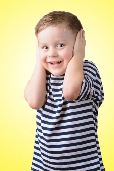 Kleiner Junge mit geschlossenen Ohren auf gelbem Hintergrund — Stockfoto