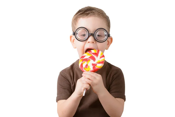 Niño comiendo una piruleta con gafas Imagen de stock