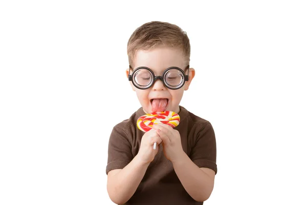 Liten pojke slicka lollipop med glasögon Stockfoto