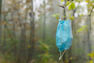 Mavi cerrahi maske, çevreye atılmış.