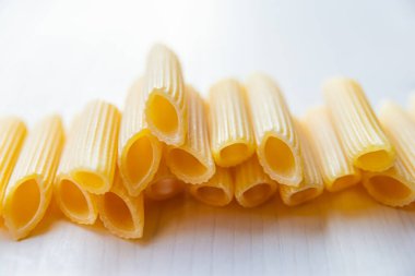 Pasta, çiğ Penne Rigate, beyaz ahşap bir yüzeyde..