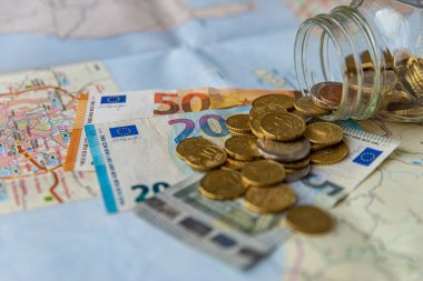 Tahta yüzeyde ve şeffaf bir kavanozda tasarruf, para ve banknotlar. Seyahat için para biriktirildi.