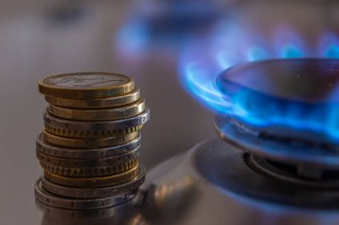 Gaz mutfak sobası, yanan ateş ve bozuk paralarla. Benzin masrafı.