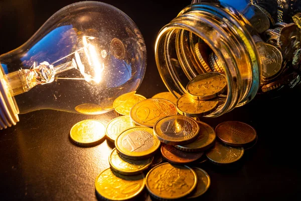 Yanında bozuk para ve ampul olan cam vazo. Faturalardan tasarruf ediyorum. Elektrik maliyetleri