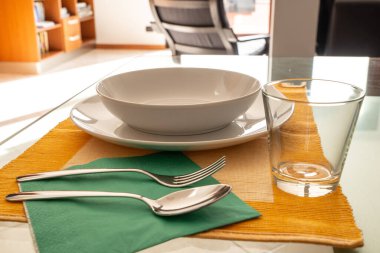 Masa ayarı. Tabaklar, çatal, kaşık, bıçak, cam, masa örtüsü.. 