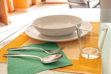 Masa ayarı. Tabaklar, çatal, kaşık, bıçak, cam, masa örtüsü.. 