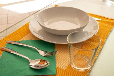 Masa ayarı. Tabaklar, çatal, kaşık, bıçak, cam, masa örtüsü.. 